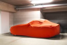 expensive-new-car-with-orange-cover-protection-parked-garagemodern-sports-car-min